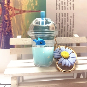 Macro view of blue whale floating in acrylic milk tea cup keychain with flower detail