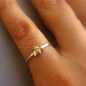 Elegant honey bee ring in silver and gold tones shown as worn on a woman finger