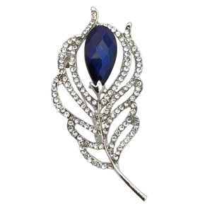 Macro detail of leaf brooch with blue pear-cut crystal and sparkling white rhinestones