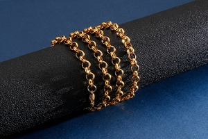 Détail d'une chaîne en acier inoxydable plaqué or enroulée sur un support noir chic