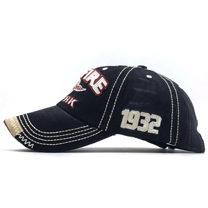 Detailed side view of washed cotton baseball cap with 1932 embroidery and distressed brim
