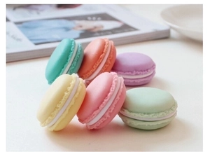 Macro view of macaron-shaped mini jewelry storage boxes in various pastel colors