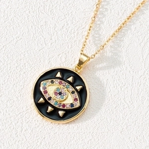 Detailed macro shot of a gold-plated evil eye pendant with colorful zircon stones