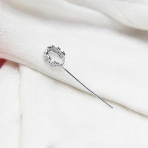 Close-up of S925 sterling silver DIY pendant clasp with circular hollow design on white fabric