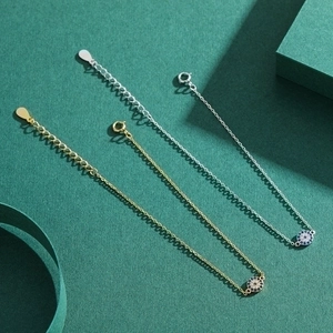 Elegant gold and silver S925 sterling silver evil eye bracelets on green background