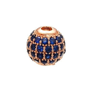 Macro shot of rose gold bead with pave-set dark blue crystals for DIY jewelry