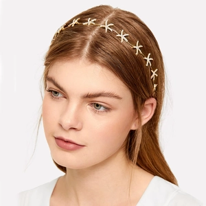 Golden bridal starfish headband with sparkling rhinestones on a model in profile