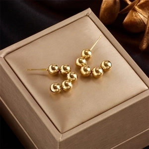 Macro shot of five gold polished metal beads arranged in an arc on a luxury gift box