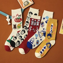 Detail of four colorful preppy style mid-tube socks with cartoon face embroidery