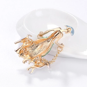 Golden metal brooch back detail with safety pin and connecting chain on white background