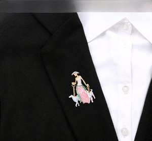 Detail of elegant enamel brooch featuring a lady walking dogs on a black suit lapel