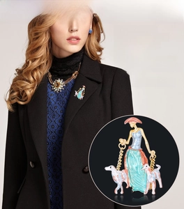 Detail of elegant painted enamel lady with dogs brooch on a vintage style outfit