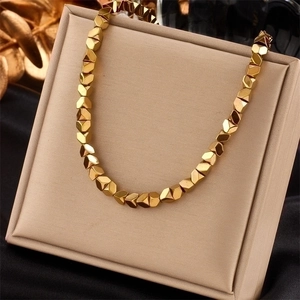 Minimalist gold titanium steel necklace with geometric faceted beads on a display