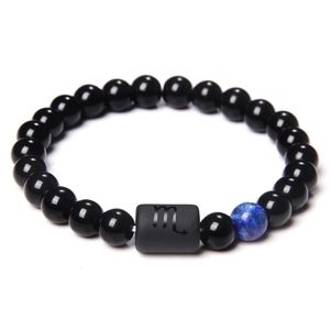 Close-up of Scorpio beaded bracelet with polished black beads and blue accent stone