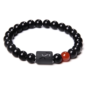Macro shot of Sagitarrius zodiac beaded bracelet with black stones and one red accent bead
