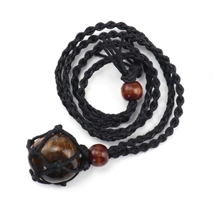 Detail of handcrafted black woven rope necklace with tiger eye stone and wooden beads