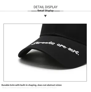 Dettaglio cappello in cotone nero con ricamo bianco e visiera rigida per una forma perfetta