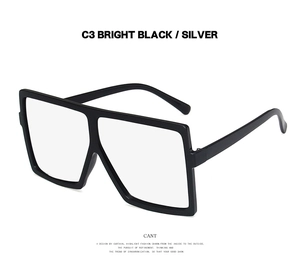 Detail of retro oversized bright black square frames with silver accents and clear lenses