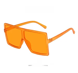 Detail view of oversized square orange sunglasses with matte finish and metal hinges
