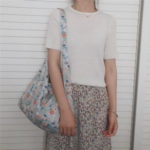 Floral cotton shoulder bag with blue patterns shown in a casual lifestyle outfit