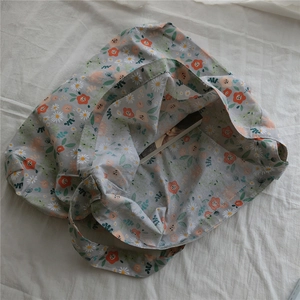 Close-up of floral canvas bag with daisy pattern and spacious interior for books