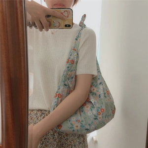 Close-up of floral cotton shoulder bag with knot strap and soft fabric texture