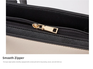 Detail of smooth golden metal zipper closure on the black and beige tote bag