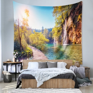 Detail view of a bohemian forest waterfall tapestry hanging above a bedroom bed