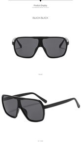 Front and 45-degree side view of oversized black wrap-around sunglasses with metal accents