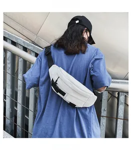 Weiße Canvas-Brusttasche mit schwarzem Nylongurt und Schnalle, am Rücken des Modells getragen