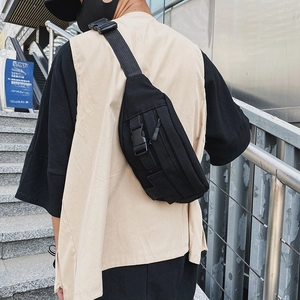 Detail einer schwarzen funktionellen Brusttasche mit verstellbaren Nylongurten und Schnallen