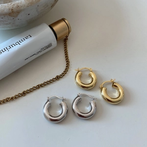 Detailed close-up of S925 sterling silver C-shaped hoop earrings with polished finish