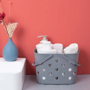 Gray plastic heart cutout bath basket with handles and bathroom supplies for storage