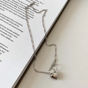 Detailed view of silver heart pendant with Figaro chain and stylish toggle clasp closure