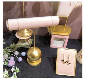 Detail of pink velvet and gold metal jewelry stand for earrings and necklaces