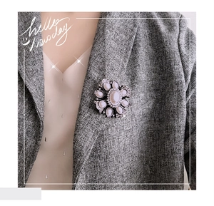 Close-up of a Baroque pearl flower brooch pinned on a dark grey wool blazer lapel