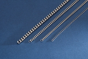 Detail showing four silver titanium steel necklaces in various thicknesses on blue background