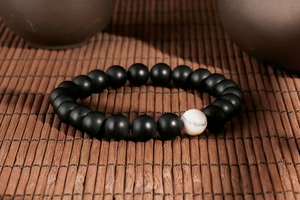 Detail of matte black beads and white marble turquoise stone on a stretch bracelet