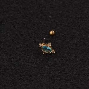 Macro view of gold stud earring with oval blue stone and sparkling clear crystals