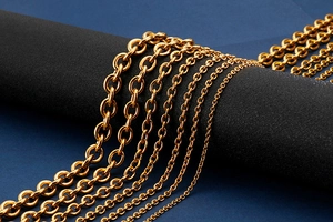 Macro shot of multiple gold-toned stainless steel cross chains on dark display