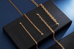 Detail of assorted gold stainless steel O-chains with lobster clasps on a black pedestal