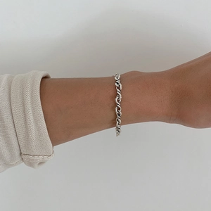 Close-up of a handcrafted 925 sterling silver twisted chain bracelet on a wrist