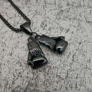 Close-up of black boxing glove pendant on matching box chain with polished finish