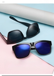 Detail of oversized black sunglasses with classic dark and blue tinted lenses