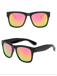 Close-up of black oversized sunglasses featuring pink to green gradient reflective lenses
