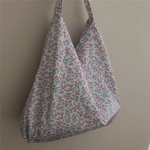 Floral cotton tote bag with vintage blue leaves and pink flowers on white wall