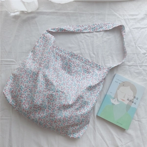 Detail shot of a floral cotton tote bag with soft pink patterns on white fabric background