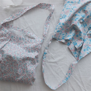 Detail of soft cotton floral tote bags showing delicate pink and blue flower patterns
