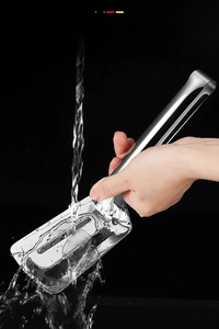 Detail of 304 stainless steel food tongs being rinsed under water on dark background