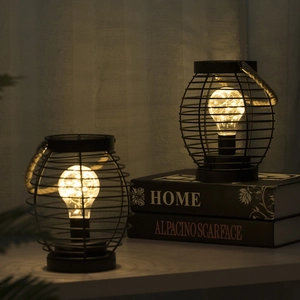 Detail of black iron wire cage lamps with warm copper wire lights and rope handles